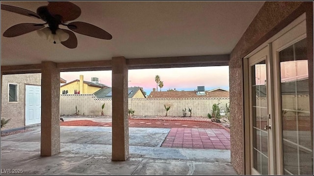 patio terrace at dusk featuring ceiling fan