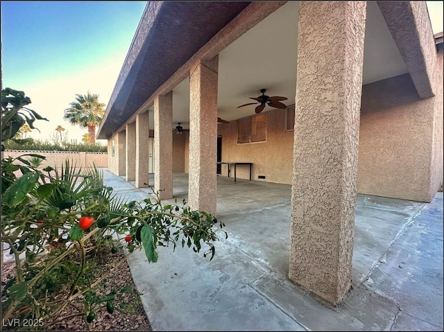 patio terrace at dusk featuring ceiling fan