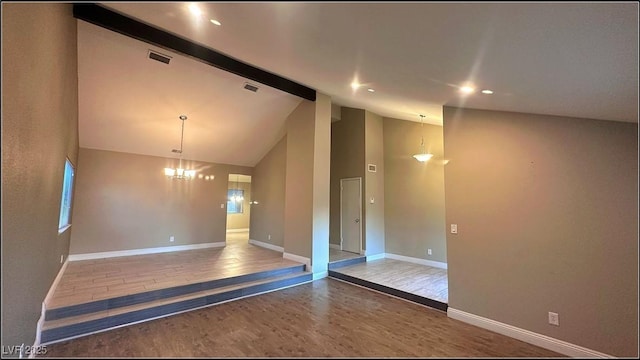 spare room featuring hardwood / wood-style floors, beamed ceiling, a chandelier, and high vaulted ceiling