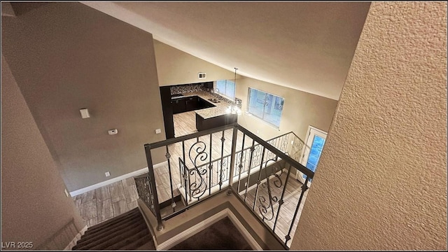 stairs featuring high vaulted ceiling