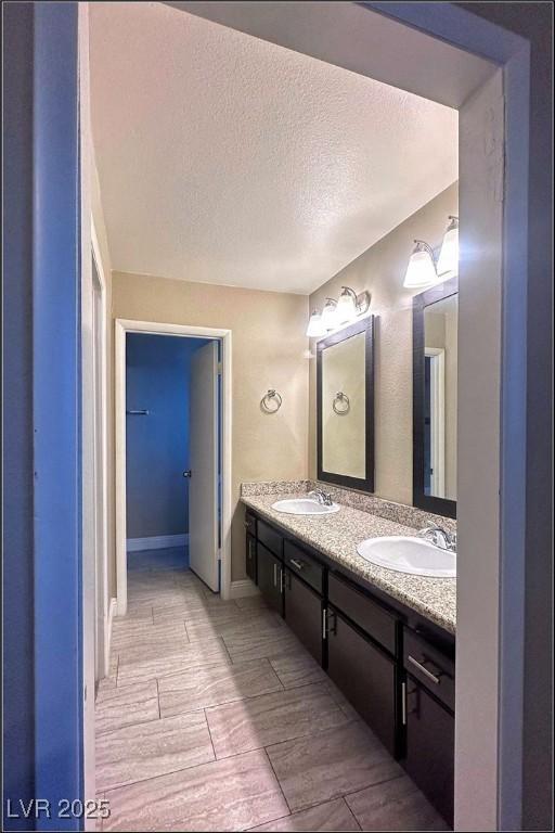 bathroom featuring a textured ceiling and vanity