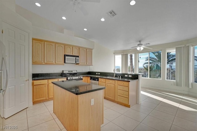 kitchen with a center island, light brown cabinets, sink, light tile patterned floors, and stainless steel appliances