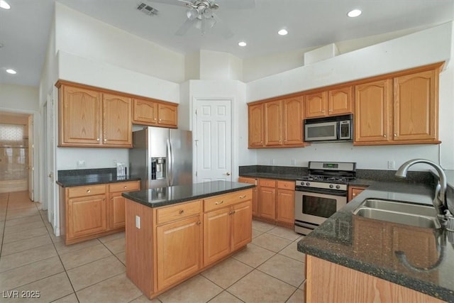 kitchen featuring a center island, sink, ceiling fan, appliances with stainless steel finishes, and light tile patterned flooring