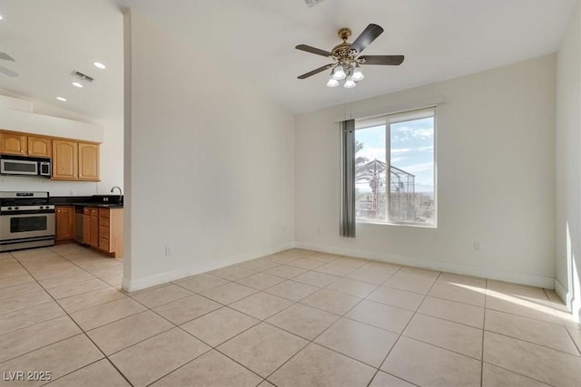 interior space featuring ceiling fan, light tile patterned floors, sink, and lofted ceiling