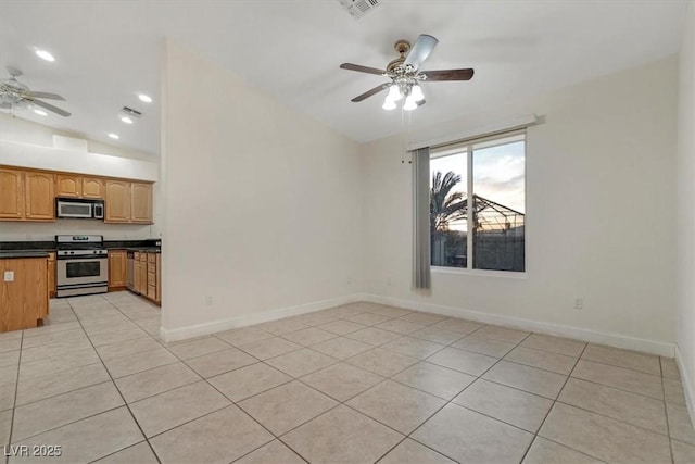 kitchen featuring ceiling fan, light tile patterned floors, vaulted ceiling, and appliances with stainless steel finishes