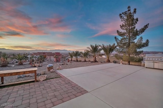 patio terrace at dusk with grilling area and a mountain view