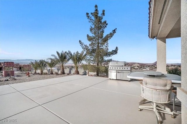 view of patio / terrace with a mountain view and a grill