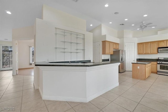 kitchen featuring a center island, light brown cabinets, ceiling fan, light tile patterned floors, and appliances with stainless steel finishes