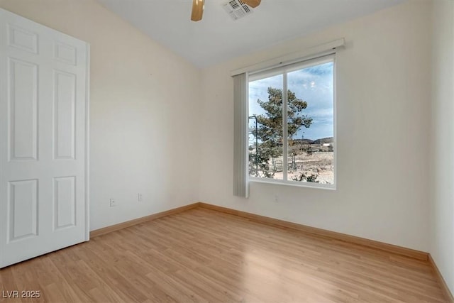 spare room with vaulted ceiling, light hardwood / wood-style flooring, and ceiling fan