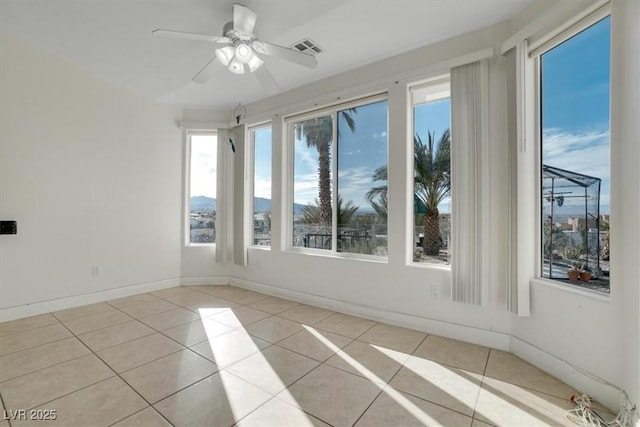 tiled spare room featuring ceiling fan and plenty of natural light