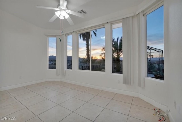 spare room featuring ceiling fan and light tile patterned floors