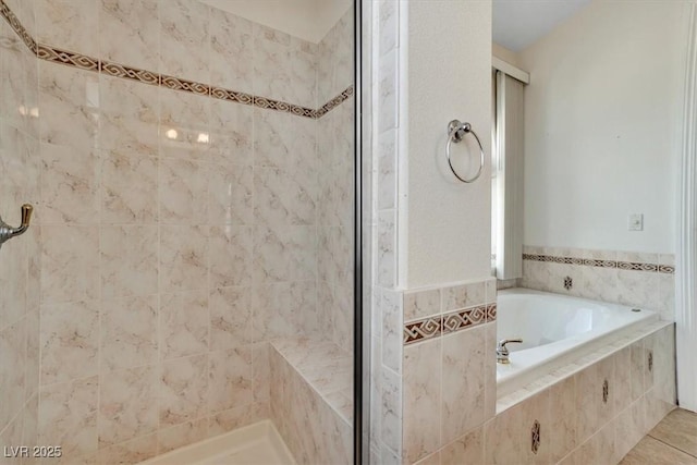 bathroom featuring tile patterned flooring, tile walls, and independent shower and bath