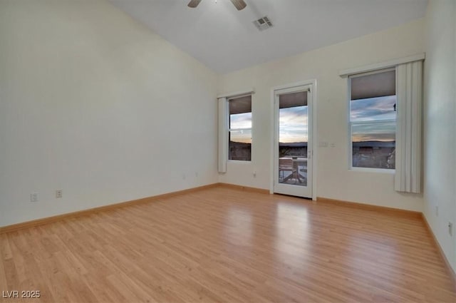 spare room featuring light wood-type flooring, vaulted ceiling, and ceiling fan