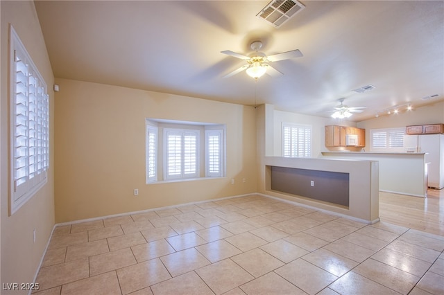 tiled spare room featuring ceiling fan