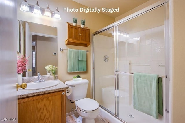 bathroom featuring a shower with door, vanity, and toilet