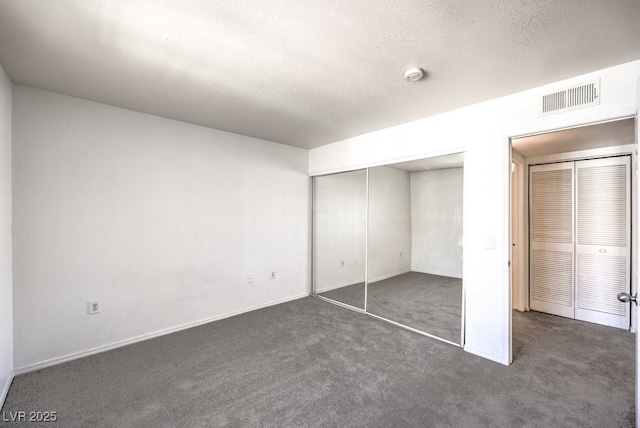 unfurnished bedroom with a closet and dark colored carpet