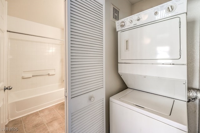 clothes washing area with stacked washer / dryer