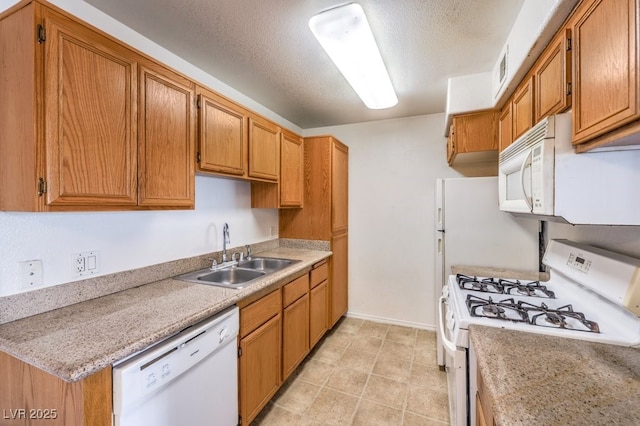 kitchen featuring a textured ceiling, white appliances, and sink