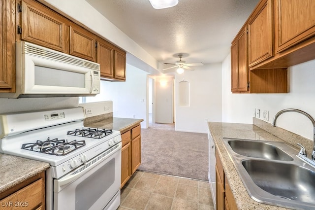 kitchen with ceiling fan, sink, light colored carpet, a textured ceiling, and white appliances