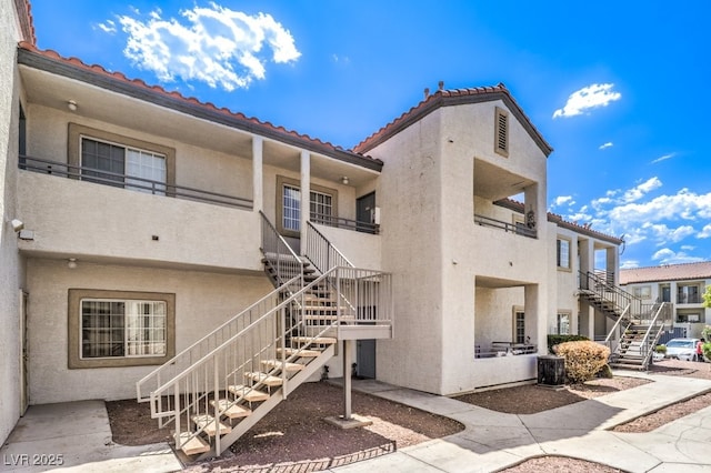 rear view of property featuring a balcony and central air condition unit