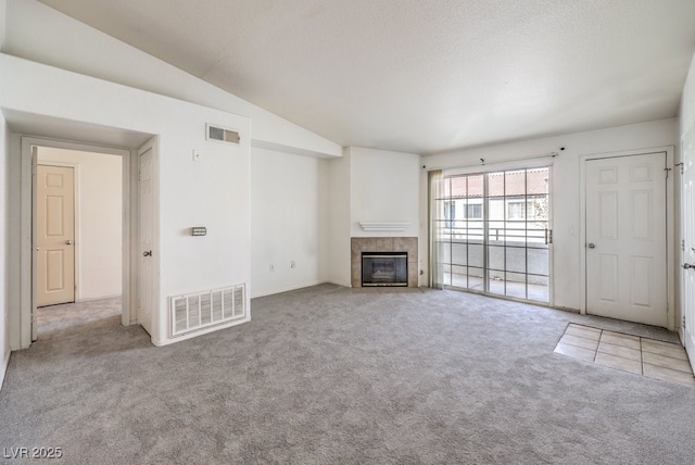 unfurnished living room with a fireplace, light colored carpet, and lofted ceiling