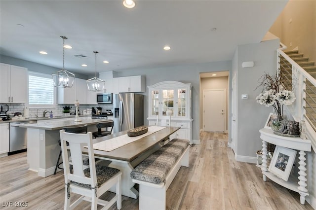 dining area with light hardwood / wood-style flooring and sink