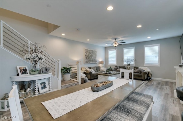 living room with hardwood / wood-style floors, ceiling fan, and a fireplace