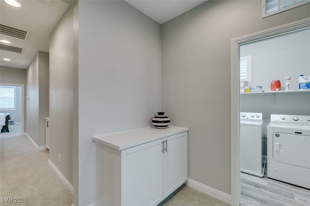 washroom featuring light colored carpet and washer and clothes dryer