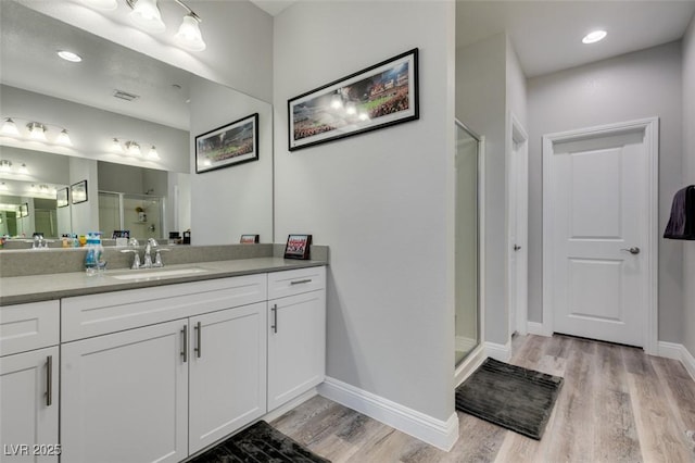 bathroom featuring vanity, an enclosed shower, and wood-type flooring