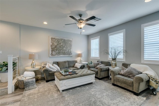 living room with wood-type flooring and ceiling fan