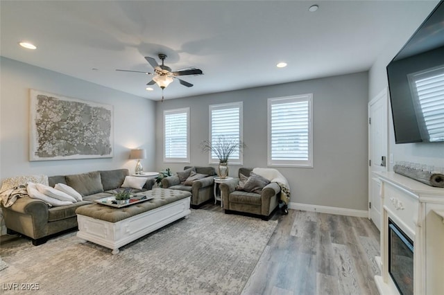 living room with ceiling fan and light hardwood / wood-style flooring