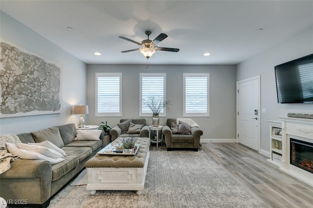 living room with ceiling fan and light wood-type flooring