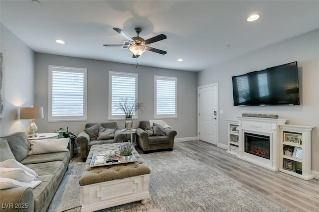 living room featuring ceiling fan and light hardwood / wood-style floors