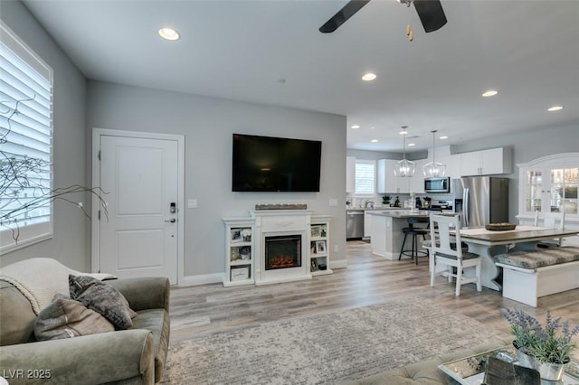 living room featuring ceiling fan and light wood-type flooring