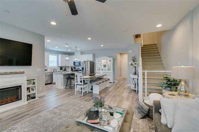 living room with ceiling fan and light wood-type flooring