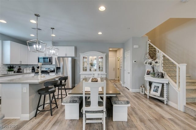 dining space with a chandelier and light hardwood / wood-style floors