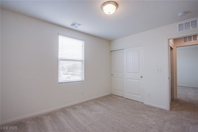 unfurnished bedroom with light carpet and a closet