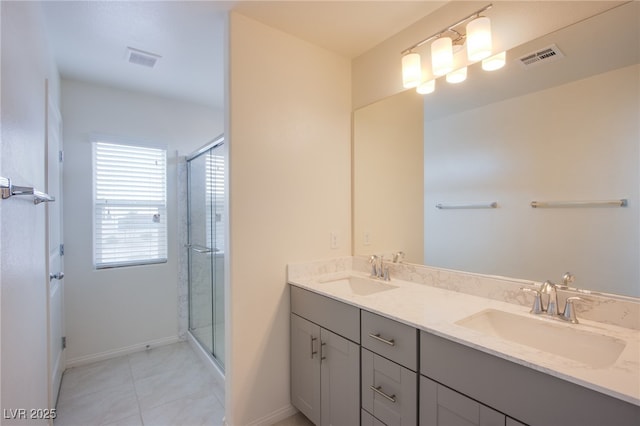 bathroom featuring tile patterned floors, a shower with door, and vanity