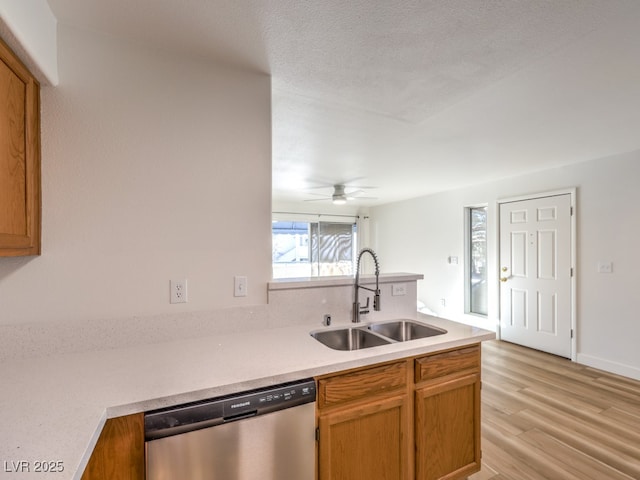 kitchen featuring sink, stainless steel dishwasher, ceiling fan, light wood-type flooring, and kitchen peninsula