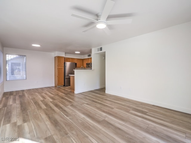 unfurnished living room with ceiling fan and light wood-type flooring