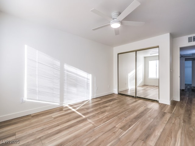 unfurnished bedroom with ceiling fan, light hardwood / wood-style floors, and a closet