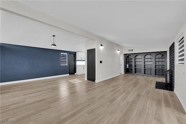 unfurnished living room featuring light hardwood / wood-style floors and vaulted ceiling