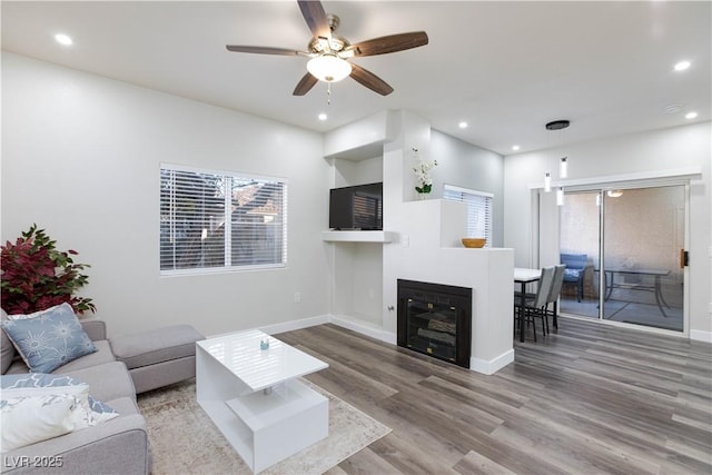 living room featuring hardwood / wood-style floors and ceiling fan