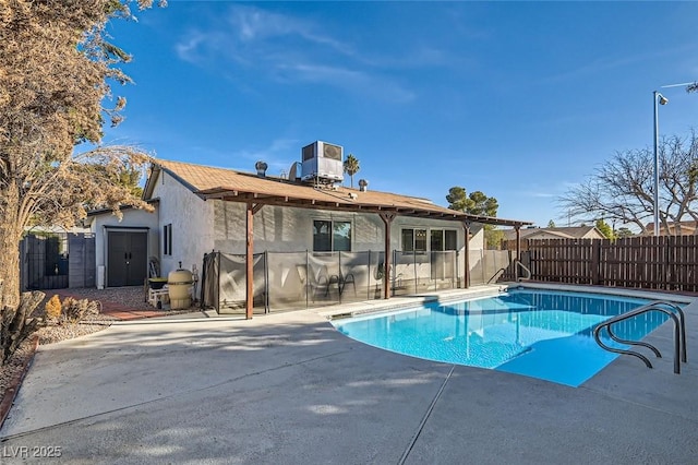 view of swimming pool featuring central air condition unit, a storage shed, and a patio