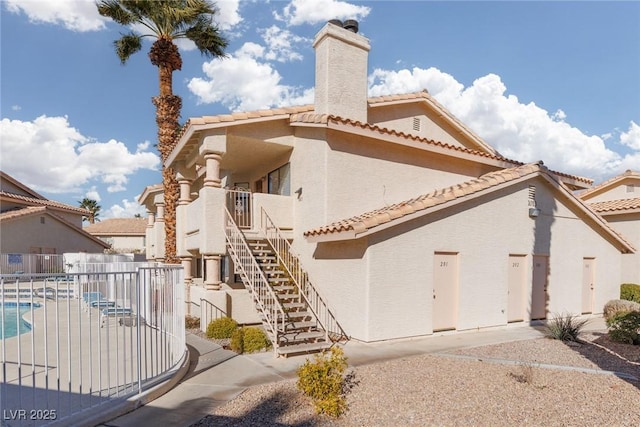 rear view of property featuring a patio area and a community pool