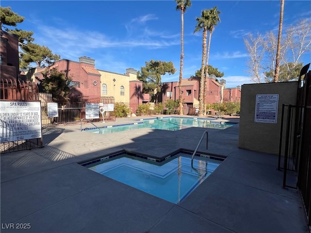 view of swimming pool featuring a community hot tub and a patio