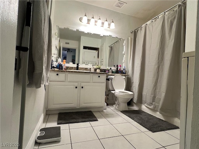 full bathroom with tile patterned floors, shower / bath combo with shower curtain, vanity, and toilet