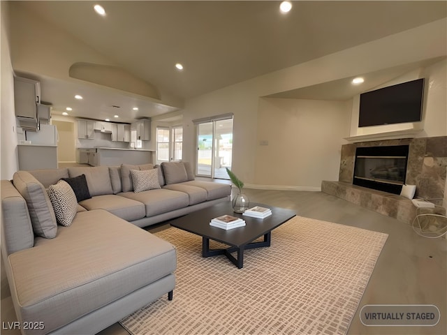 living room with a tile fireplace and lofted ceiling