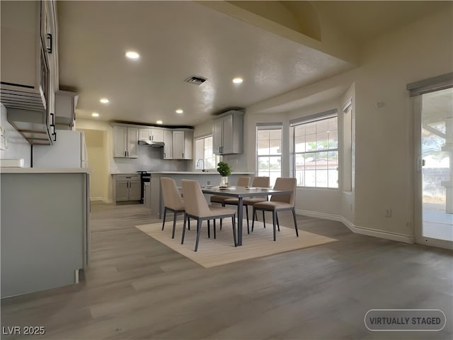 dining area with sink and light hardwood / wood-style floors