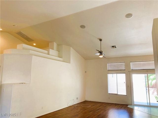 empty room with hardwood / wood-style floors, ceiling fan, and vaulted ceiling